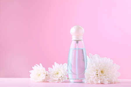 Bottle of perfume with flowers on pink background with copy spaceの写真素材