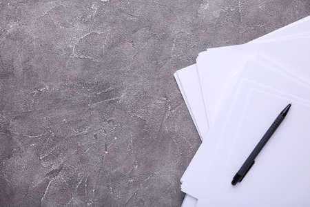 Stack white paper with pen on gray backgroundの写真素材