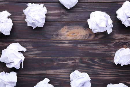 Crumbled paper on a brown wooden background, frameの写真素材