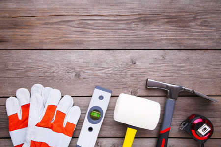Different construction tools on wooden background with copy space.