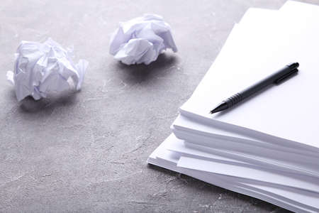 Stack white paper with pen on gray background
