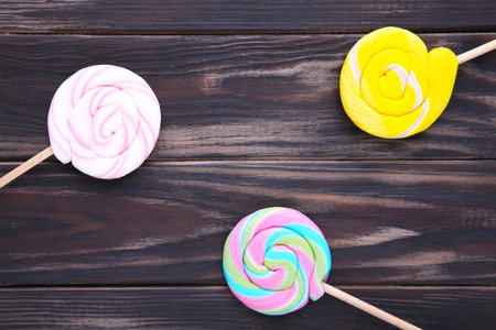 Colorful lollipops on brown wooden background.の写真素材