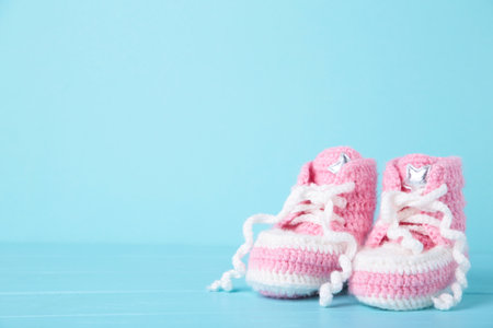 Pink baby booties on a blue background, top view