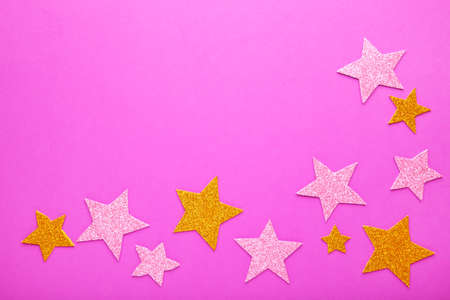 Golden and pink glittering star on pink background with copy space