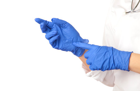 Doctor putting on sterile blue gloves isolated on white background. Top view