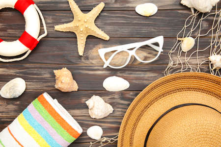 Beach accessories with palm leaves on brown background. Top viewの写真素材
