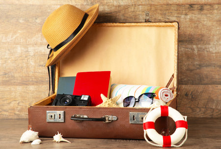 Vintage suitcase and beach accessories on brown background. Summer conceptの写真素材