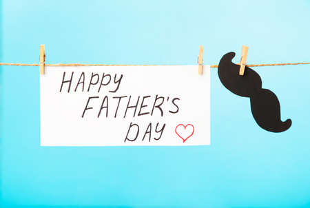 Happy Fathers Day written on paper with mustache on blue background. Top viewの写真素材