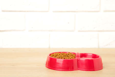 Red pet bowl on the light background. Top view