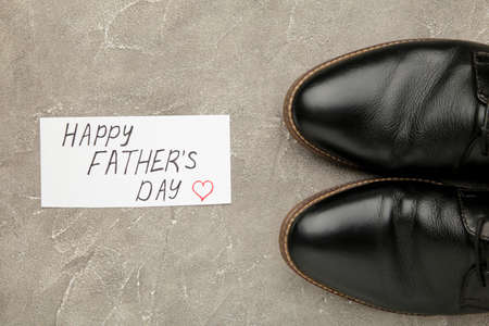 Happy Fathers Day message and black shoes on concrete background. Top viewの写真素材