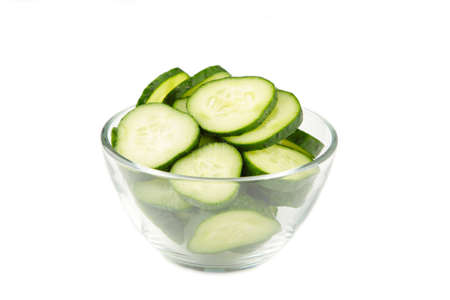 Fresh cucumber slices in bowl isolated on white background. Top viewの写真素材