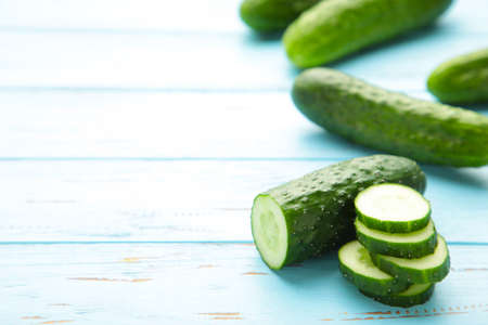 Fresh cucumber slices on blue wooden background. Top viewの写真素材