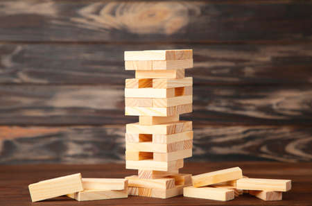 Business risk concept with wood game. Wooden blocks on brown backgroundの写真素材