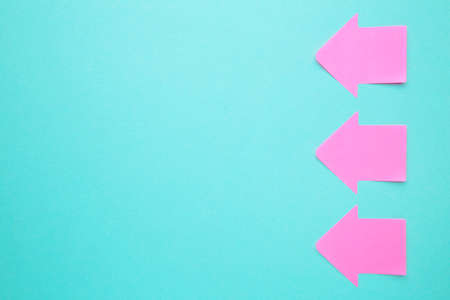 Paper sticky notes in shape of arrow on blue background. Top viewの写真素材