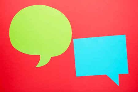 Dialog - two blank speech bubbles on red backgrounnd. Top viewの写真素材