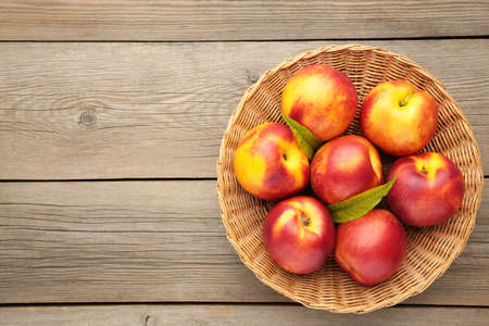 Nectarines in a basket on gray background with copy space. Top viewの写真素材
