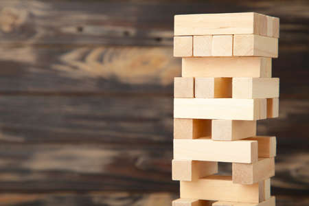 Business risk concept with wood game. Wooden blocks on brown backgroundの写真素材