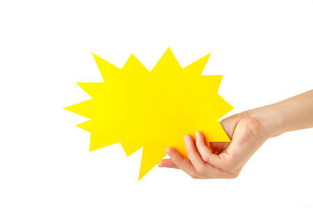 Hand holding yellow paper speech bubble isolated on white background. Top view