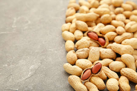 Peanuts in shells on gray concrete background. Top view