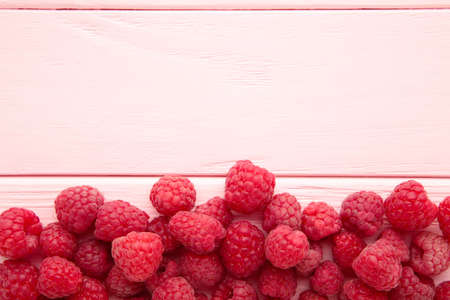 Ripe raspberries on pink wooden background with copy space. Top viewの写真素材