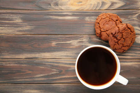 Cup of coffee and chocolate cookies on brown wooden table. Top viewの写真素材