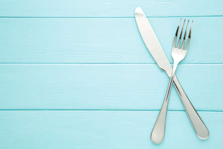 Fork and knife on a blue background. Top viewの写真素材