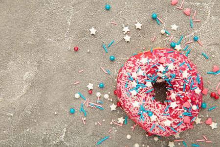 Baked sweet delicious donut with pastry crumb on gray concrete background. Food textureの写真素材
