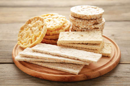 Various types of healthy whole grain crispbreads on cutting board on gray wooden background. Top viewの写真素材