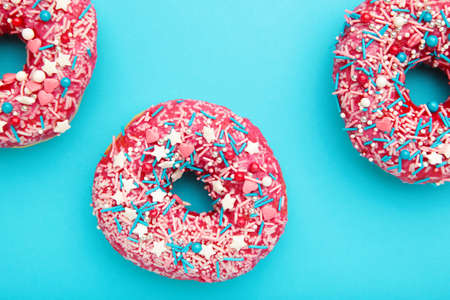 Donuts with icing on pastel blue background. Top view.の写真素材