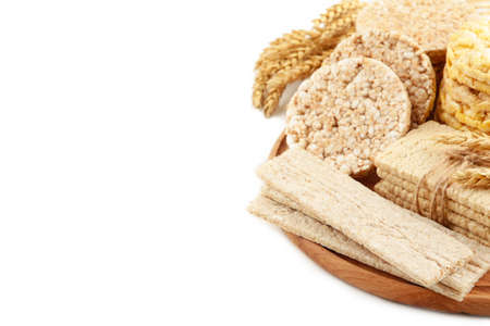 Various types of healthy whole grain crispbreads on cutting board isolated on white background. Top viewの写真素材