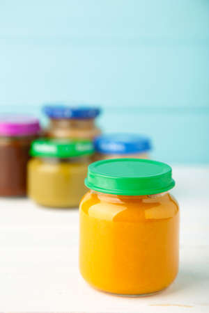 Jars of baby puree on light wooden background. Top viewの写真素材