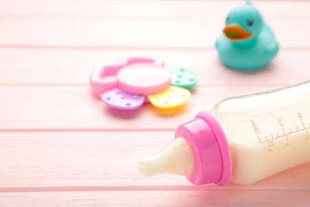 Baby milk with toys on pink background. Top viewの写真素材
