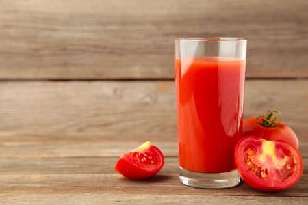 Fresh tomatoes with juice on gray wooden background. Top viewの写真素材
