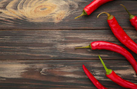 Red hot chili peppers on old wooden table. Top viewの写真素材