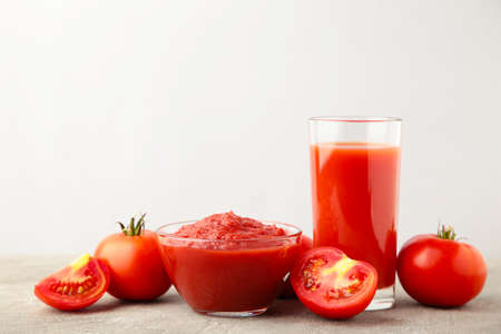 Fresh tomatoes with paste and juice on gray background. Top viewの写真素材