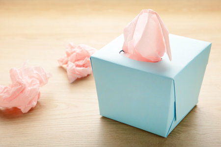 Blue box with paper tissues and used crumpled napkins on light background. Top viewの写真素材
