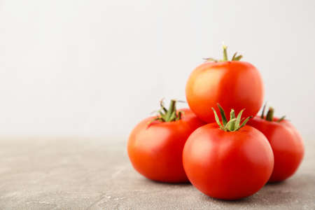 Ripe red tomatoes on a gray background. Top view