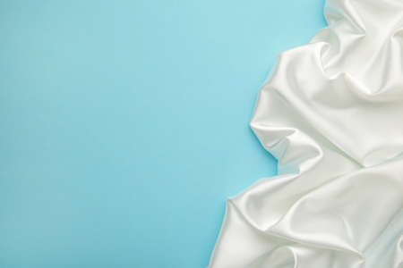 Smooth elegant white silk on blue background. Top viewの写真素材