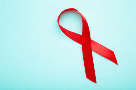 Aids awareness red ribbon on blue background. Top view