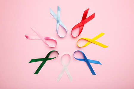 Collection of awareness ribbons on pink pastel background. World cancer day. Top viewの写真素材