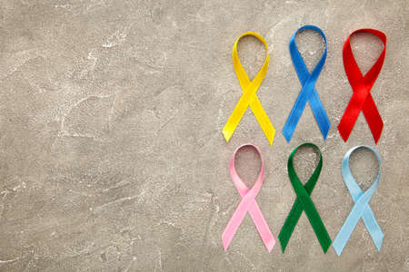 Collection of awareness ribbons on gray concrete background. World cancer day. Top viewの写真素材