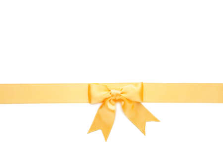 Beautiful gold ribbon and bow isolated on white background. Top view.の写真素材