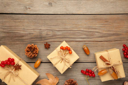 Gifts with autumn viburnum, pine cone and acorn on gray wooden background. Autumn composition. Top view, flat lay.の写真素材