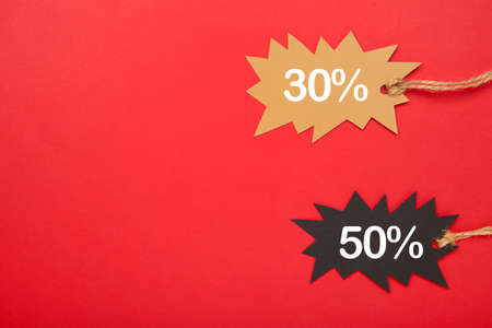 Two sale tags on red background with copy space. Top viewの写真素材
