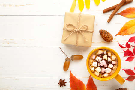 Hot chocolate and autumn leaves on gray - seasonal relax concept. Top view
