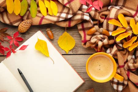 Autumn or winter composition. Cup of coffee, gift, dried autumn leaves, croissant on gray...