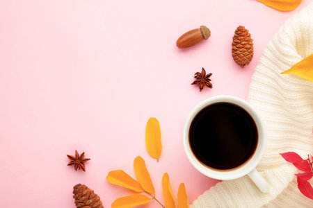 Hot coffee and autumn leaves on pink - seasonal relax concept. Cozy conceptの写真素材
