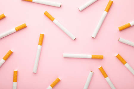 Many cigarettes on a pink background. Top view.の写真素材