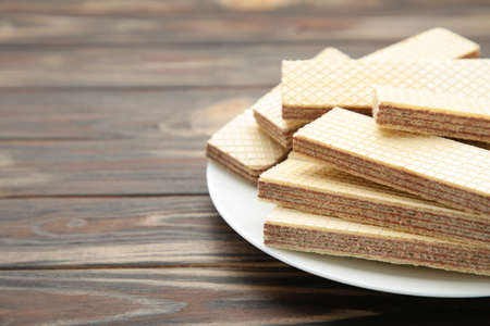 Chocolate wafers on plate on brown background. Top viewの写真素材