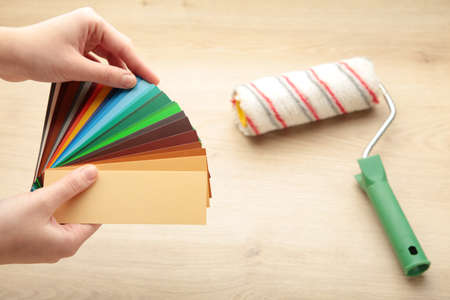Woman designer or architect choosing color from color palette. Top view.
